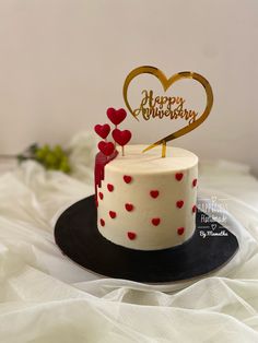 a white cake with red hearts on it