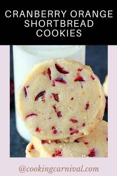 two cranberry orange shortbread cookies stacked on top of each other next to a glass of milk