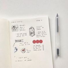 an open notebook with drawings on it next to a pen