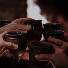 two people are holding cups in their hands