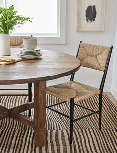 a dining room table with two chairs and a potted plant on the top of it