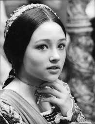 an old black and white photo of a woman wearing a tiara with her hand on her chin