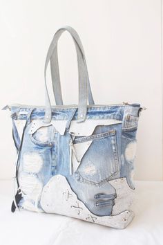 a handbag made out of old jeans with patches on the side and zippers