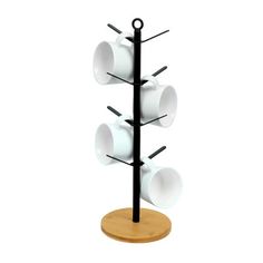 a black and white coffee cup holder with four cups on it's sides, hanging from a wooden stand