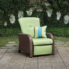 a green chair sitting on top of a brick patio