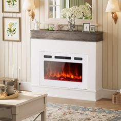 a living room with a fire place in the center and pictures on the wall above it