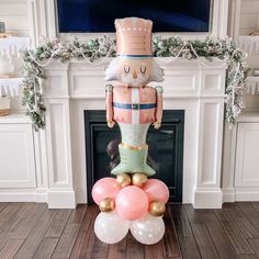 an inflatable nutcracker is sitting on top of some balloons near a fireplace