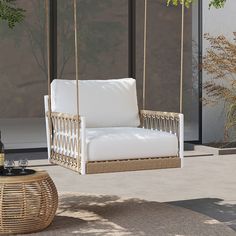 a white wicker swing chair sitting next to a window