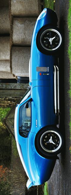 a blue car parked next to a tree