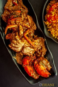 two black plates filled with food on top of a table next to another plate full of rice