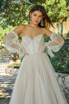 a woman in a white dress posing for the camera