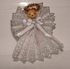 an angel ornament with a teddy bear in it's wings and a crown on its head