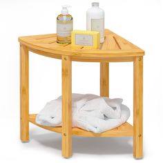 a wooden table with towels and soaps on the top, next to a bottle of lotion