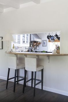 two bar stools sitting in front of a counter