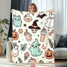 a woman holding up a halloween themed blanket