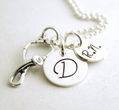 "RN Graduation Necklace Gift - Personalized Nurse Necklace RN Graduation Custom Jewelry Hand Stamped Sterling Silver Custom Nurse Necklace The 1/2\" sterling silver disc is hand stamped with the initial of your choice. The 3/8\" disc is hand stamped with the abbreviation \"R.N.\". Hanging with the name charms is a sterling silver stethoscope charm. This necklace comes on an 18\" sterling silver bead chain. If you would like to inquire about other chain options, please convo us prior to placing y Sterling Silver Necklace For Personal Use, Adjustable Silver Necklace, Sterling Silver Charm Necklace For Personalized Gifts, Silver Medallion Charm Necklace For Personalized Gift, Personalized Silver Medallion Charm Necklace, Nickel-free White Charm Necklace For Personalized Gift, Nurse Necklace, Stethoscope Charms, Graduation Necklace