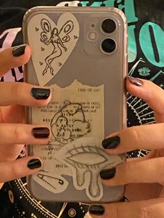 two hands holding an iphone case with drawings on it