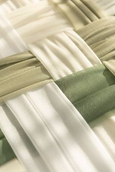 white, green and beige ribbons are lined up on a tablecloth or bed sheet