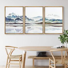 three paintings hanging on the wall above a table with two chairs and a potted plant