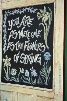 a chalkboard sign that reads, you are welcome as the flowers of spring