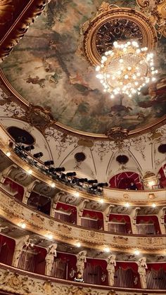 an ornately decorated auditorium with chandelier and painted ceiling