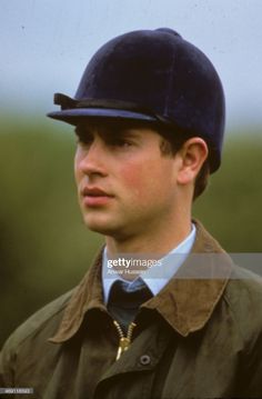 a young man wearing a blue hat and jacket, looking off to the side with his head