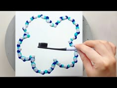 a toothbrush in the shape of a heart is being held by someone's hand