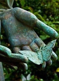 a statue of two hands holding something in it's palm