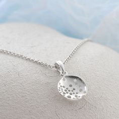 Our Wonderful Sterling Silver Bubble Dish Necklace uses a beautiful abstract design to create a truly interesting piece of jewellery . This gorgeous sterling silver necklace is perfect for people who like their jewellery with extra design and flare. This necklace can be made even more personal by the addition of some initial letter charms or a key and pearl combination. Why not complete the set with our matching sterling silver swirling waves earrings. All Martha Jackson jewellery comes complete with a gift box and blank gift card for you to write a short message on  Made from: Sterling silver Dimensions Pendant/earring diameter 1.9cm available on either a 40-45cm, 50cm or 61cm belcher chain. Add on key charm 1.3x0.5cm. Letter charms vary in size from 1cm to 1.5cm long. Nickel-free Drop Sterling Silver Necklace, Sterling Silver Drop Necklace Nickel Free, Sterling Silver Drop Necklaces, Sterling Silver Drop Necklace With Large Pendant, Sterling Silver Hallmarked Round Pendant Necklace, Unique Silver Drop Necklaces, Unique Silver Drop Necklace, Modern Sterling Silver Necklace In Silver, Sterling Silver Necklace With Flower Pendant