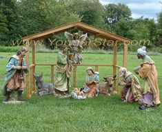 an outdoor nativity scene with figurines in the grass