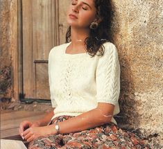 a woman sitting on the ground with her eyes closed