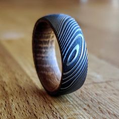 a wooden ring sitting on top of a wooden table next to a wood floor with an abstract design