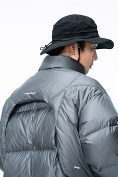 Inspired by the aerodynamic spoilers of racing cars, the Wing Force Down Jacket is a futuristic marvel in apparel design. Its silver-gray color scheme embodies a sleek, modern aesthetic. The jacket is thoughtfully equipped with two waterproof zippered pockets on the front, ensuring practical storage options while maintaining style. Filled with 286g of high-quality white duck down, it promises exceptional warmth. The fabric is also treated for water resistance, making it a versatile choice for di Grey Jacket Outfit, Tech Clothing, Technical Clothing, Grey Color Scheme, The Wing, Futuristic Fashion, Practical Storage, Hooded Parka, White Duck