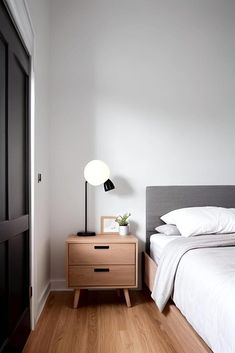 a bedroom with white walls and wood flooring