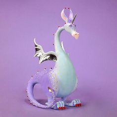 a blue and white dragon figurine sitting on top of a purple surface with sprinkles