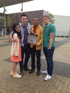 four people posing for the camera on a brick walkway