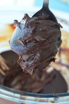 a spoon full of chocolate frosting on top of a plate