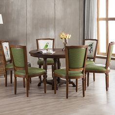 a dinning room table with green upholstered chairs in front of a window