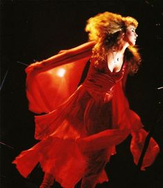 a woman in a red dress is flying through the air