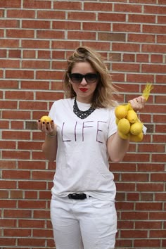 a woman holding lemons in front of a brick wall with the caption, 20 when life gives you lemons