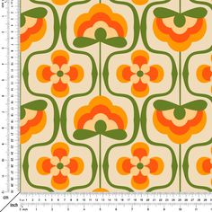 an orange and green flower pattern on a white background, with a ruler in the foreground