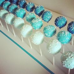 there are many blue and white cake pops on the table