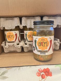 jars of pickled vegetables sit in a cardboard box