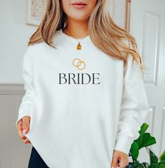 💖 Bride Sweatshirt 💖 Searching for the perfect gift for a bride-to-be? Look no further! This adorable and comfy sweatshirt is a must-have for all wedding festivities. 🎉✨ With its relaxed fit and soft fabric, it's perfect for lounging or getting ready on the big day! Ideal for bridal showers, bachelorette parties, and all those special moments leading up to "I do!" 💍🥂 🌟 Product Features: Stylish Fit: 1x1 ribbed collar, cuffs, and bottom hem for a polished look. Ultimate Comfort: Necktape for added coziness and stability. Chic Detail: Back detail featuring a half-moon neck patch for that extra touch. Luxurious Fabric: Made from 80% cotton and 20% polyester for an indulgent feel. Eco-Friendly: OEKO-TEX certified low-impact dyes for conscious consumers. 🌍💚 🧼 Care Instructions: Machine Bride Sweater, Bachelorette Party Shirt, Mrs Sweatshirt, Bride Sweatshirt, Mrs Shirt, White Bride, Comfort Colors Sweatshirt, Bride Squad, Bride Shirts