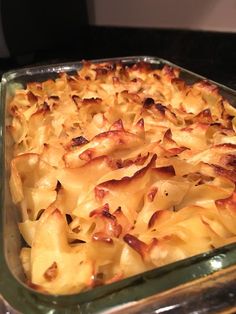 a casserole dish with pasta and cheese in a glass baking pan on a counter