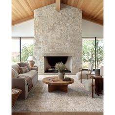 a living room filled with furniture and a fire place in front of a stone wall