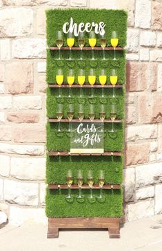 a display with grass and wine glasses on it