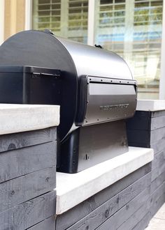 a black grill sitting on the side of a building