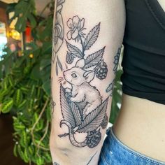 a woman's arm with a rat and flowers tattoo on the left side of her body