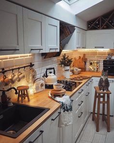 a kitchen filled with lots of counter space and white cupboards next to a stove top oven